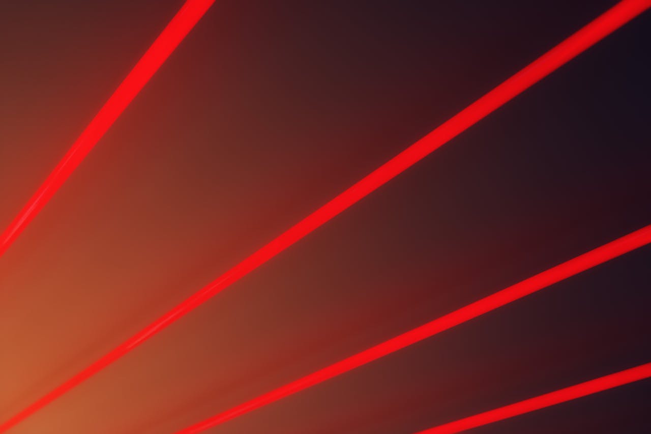 Abstract image with vibrant red laser beams on a dark gradient backdrop, illustrating futuristic design.